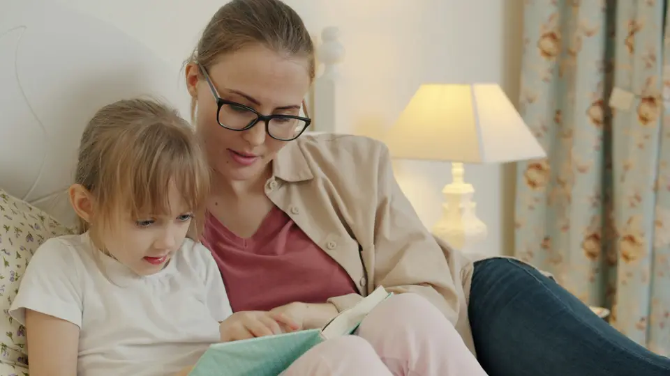 Una madre e una bambina leggono insieme un libro